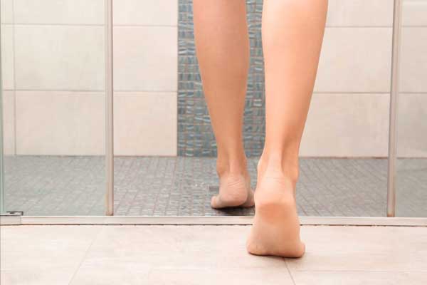 Frauenfüße in einer Dusche mit Fußbodenheizung